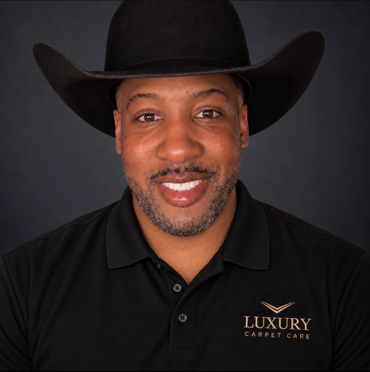 Travis of Luxury Carpet Care wearing a branded black polo and black hat